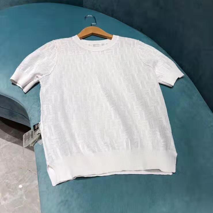 Close-up of white cotton fabric and Fendi logo detail on jumper