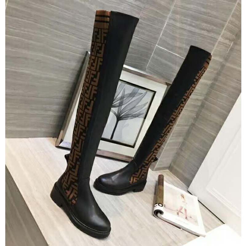 Close-up of black leather and gold hardware on Fendi thigh-high boots