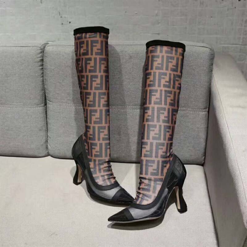 Close-up of lace-up closure and branded hardware on Fendi black boots