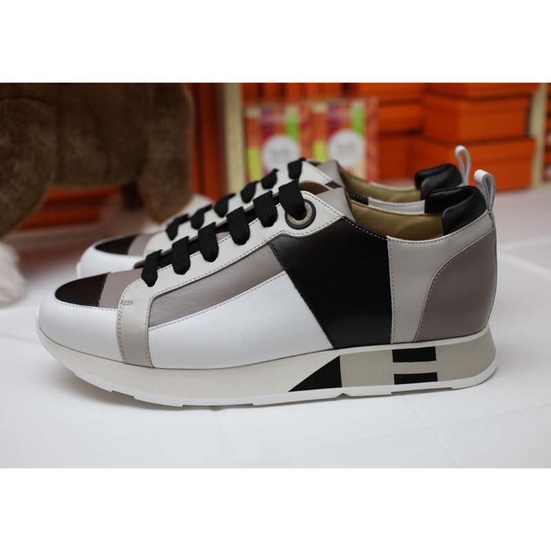Top-down shot highlighting white leather and lace-up closure of Hermes Men Rebus Sneakers