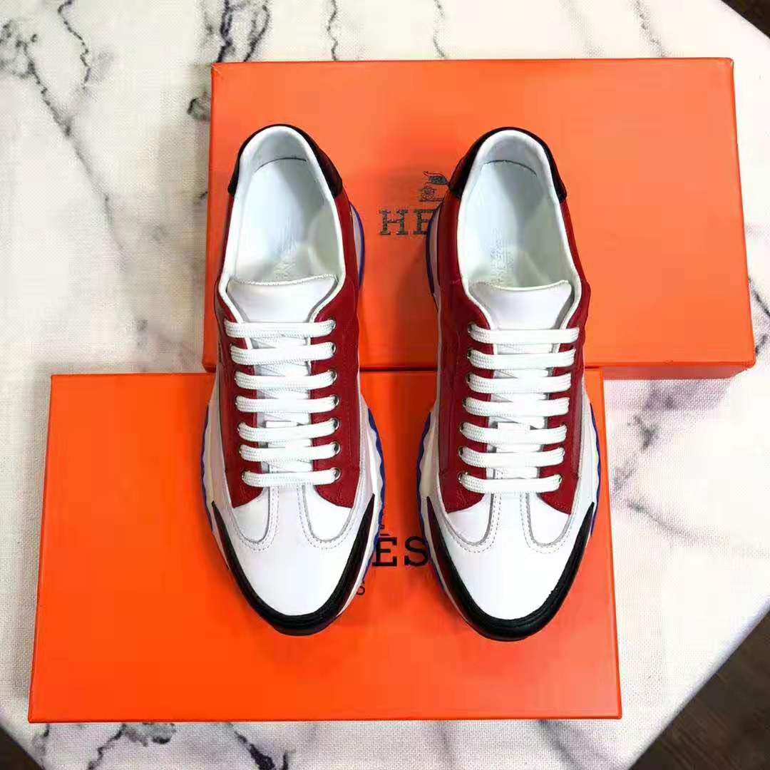 Close-up of lace-up closure and red calfskin texture on Hermes Men Trail sneaker
