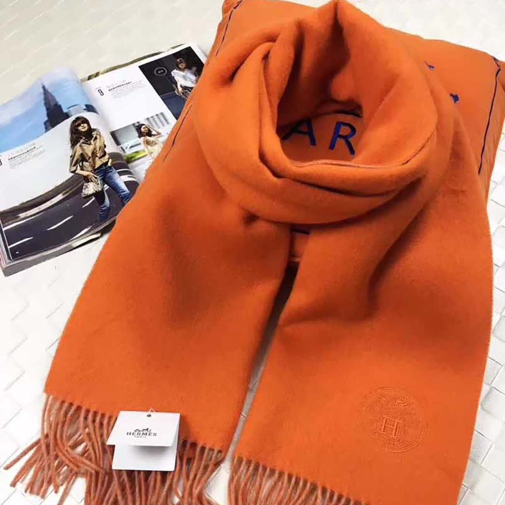 Model wearing vibrant orange Hermes Women Casaque II Stole over shoulders