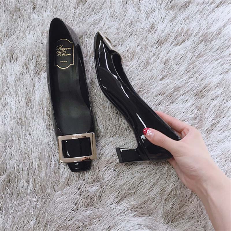 Top-down angle showing polished black patent leather on Roger Vivier pumps