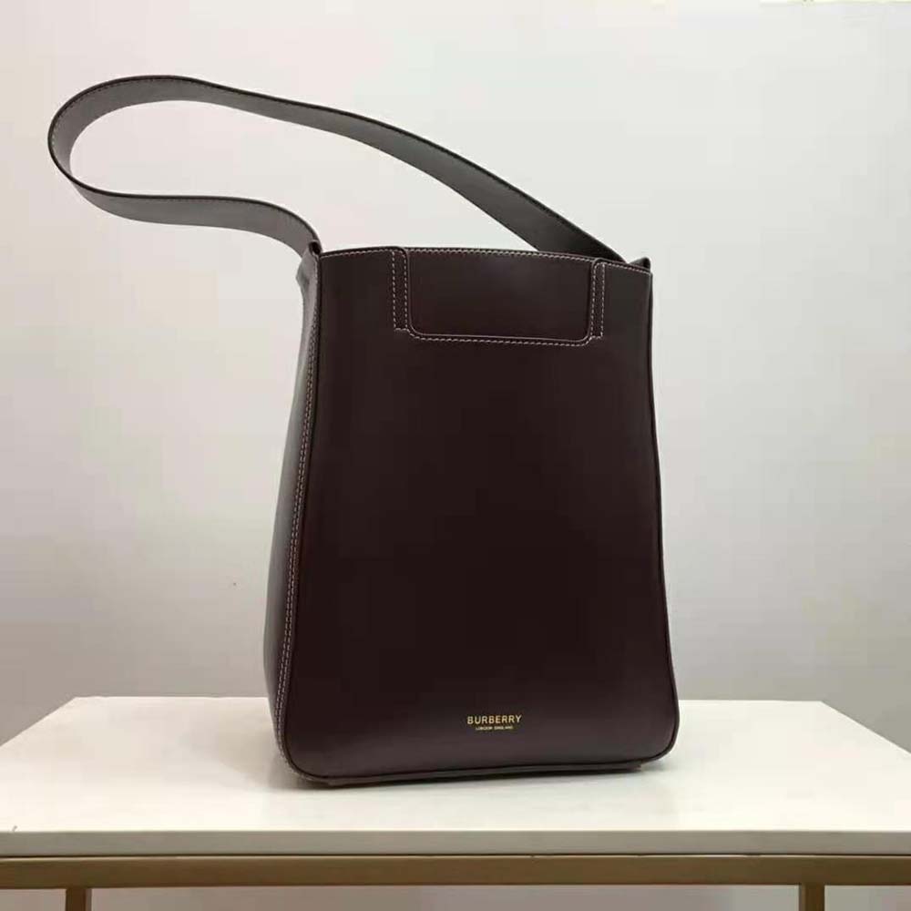 Close-up of maroon leather texture and gold-tone hardware on Burberry basket bag