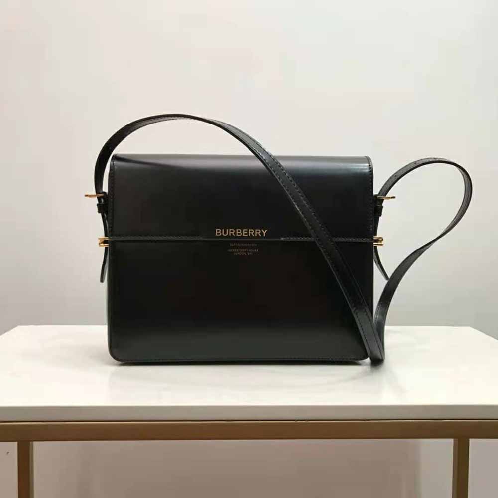 Close-up of black leather texture and signature silver closure detail