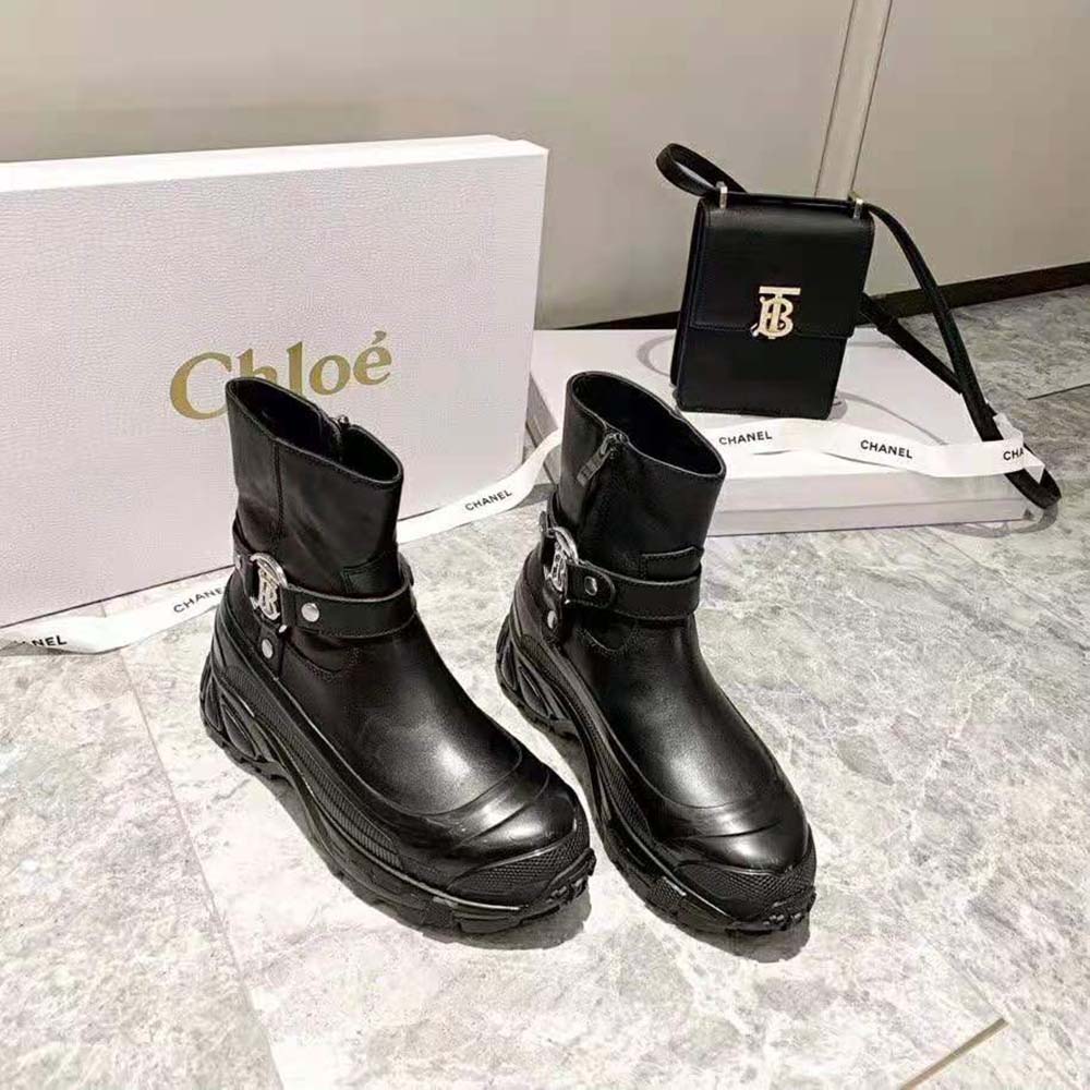 Close-up on monogram motif buckle detail of Burberry black boots