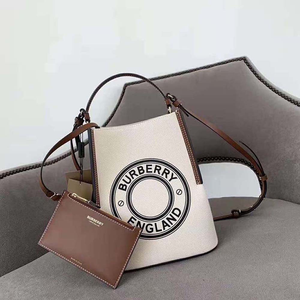 Close-up of gold-tone hardware and logo graphic on Peggy Bucket Bag