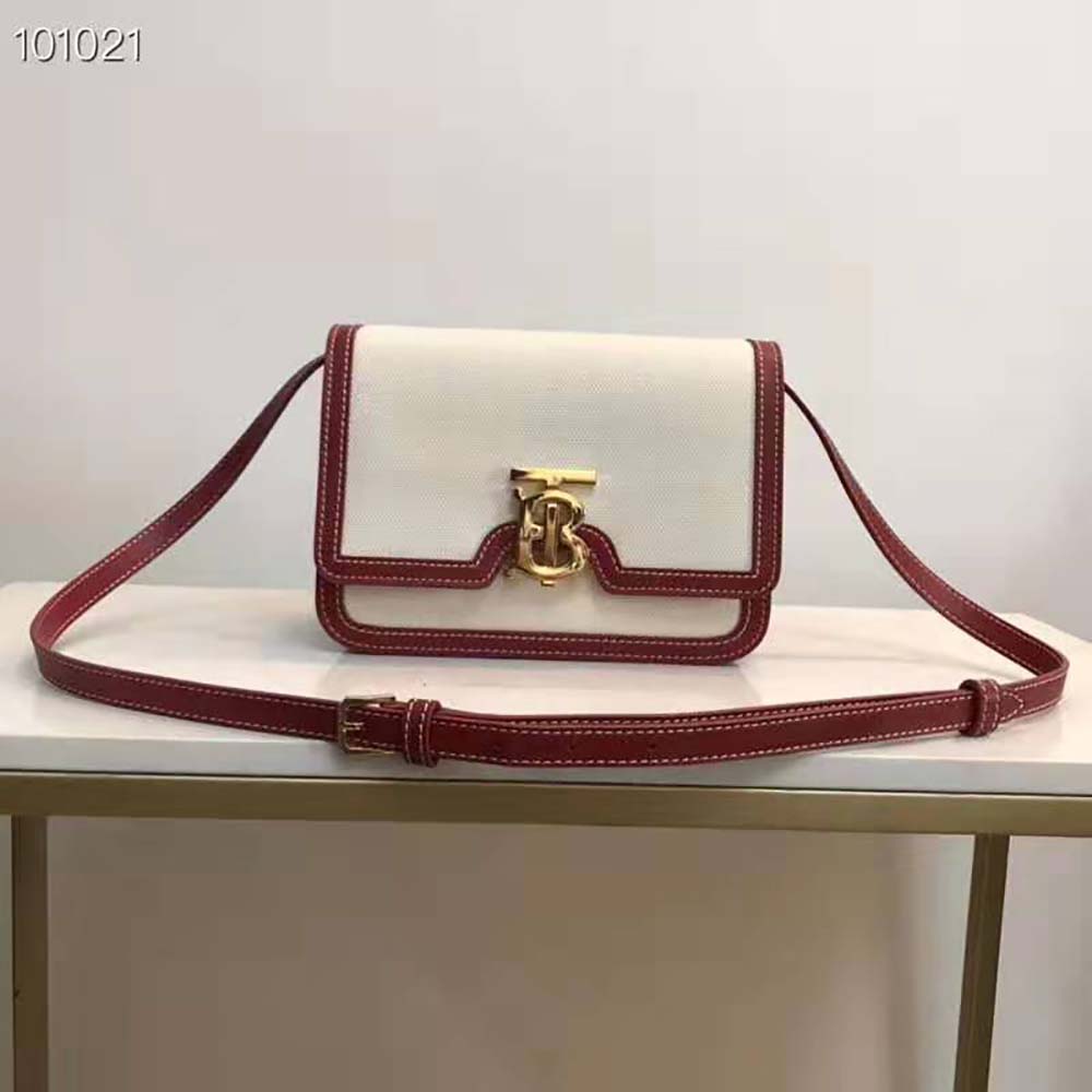 Close-up of gold TB hardware on Burberry Women Small Two-tone Canvas and Leather TB Bag-Red