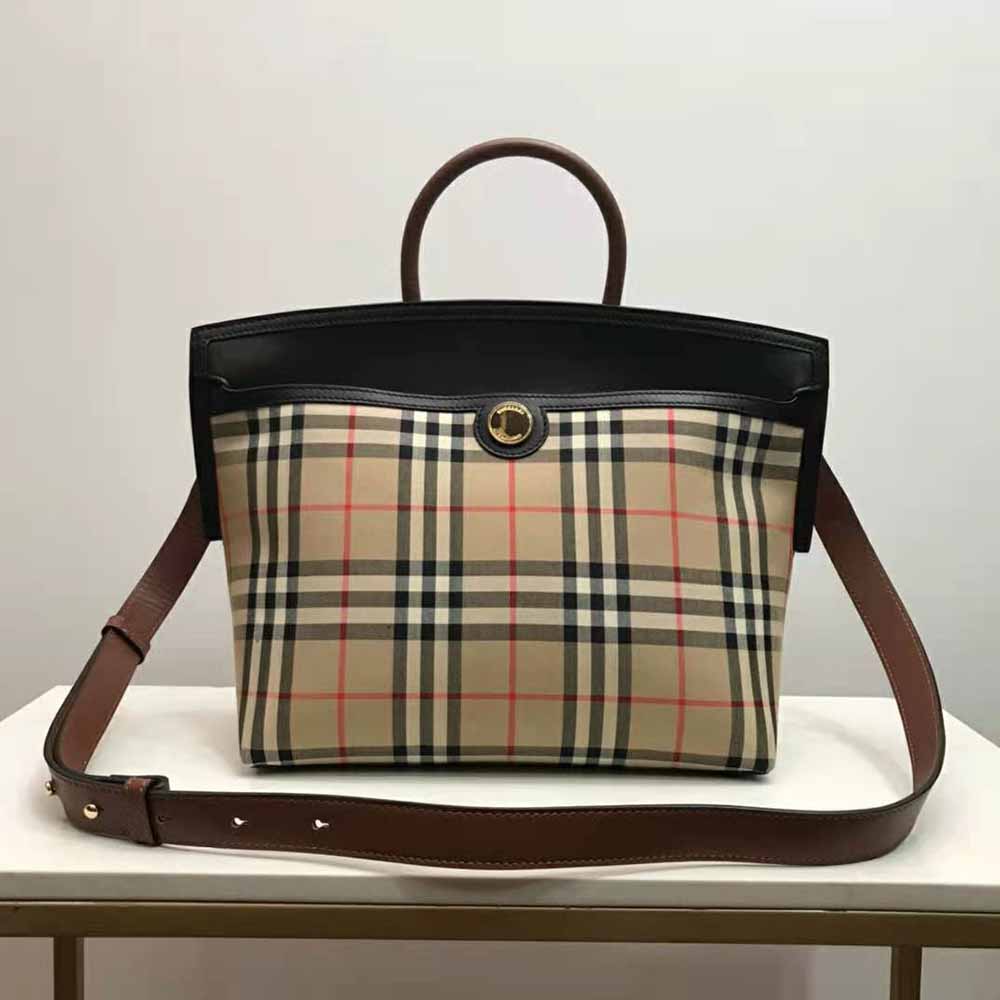 Close-up of black leather trim and gold hardware on Burberry bag