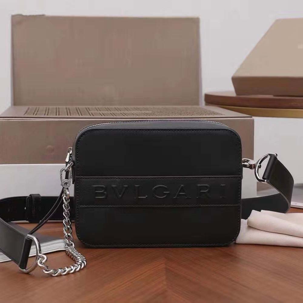 Close-up of signature BVLGARI engraved hardware on camera bag