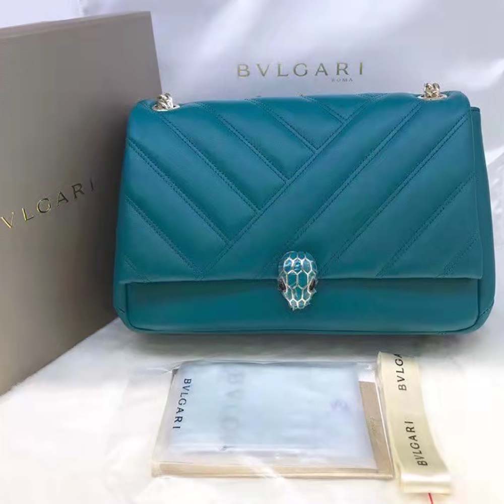 Close-up on gold snakehead clasp and green cabochon detail on Bvlgari bag