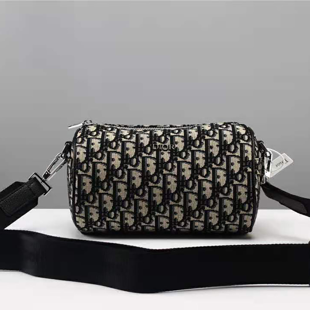Close-up detail of jacquard fabric and silver hardware on Dior messenger bag