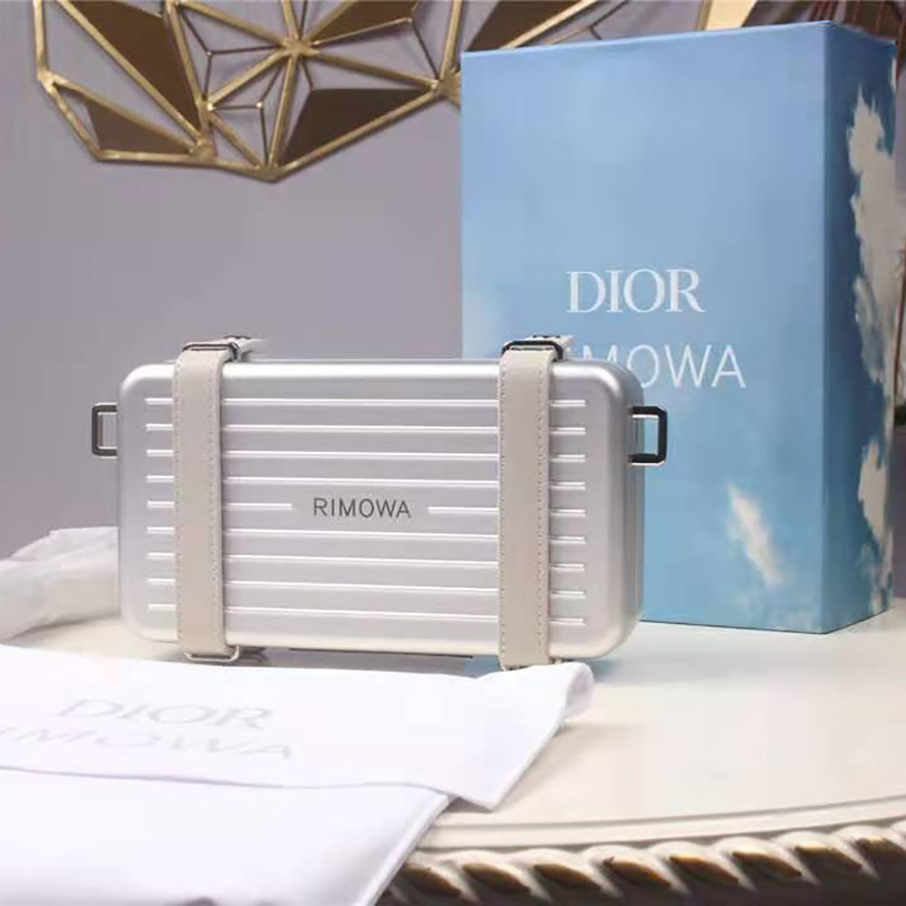 Side angle showing aluminum frame and leather texture of Dior Men Dior and Rimowa clutch