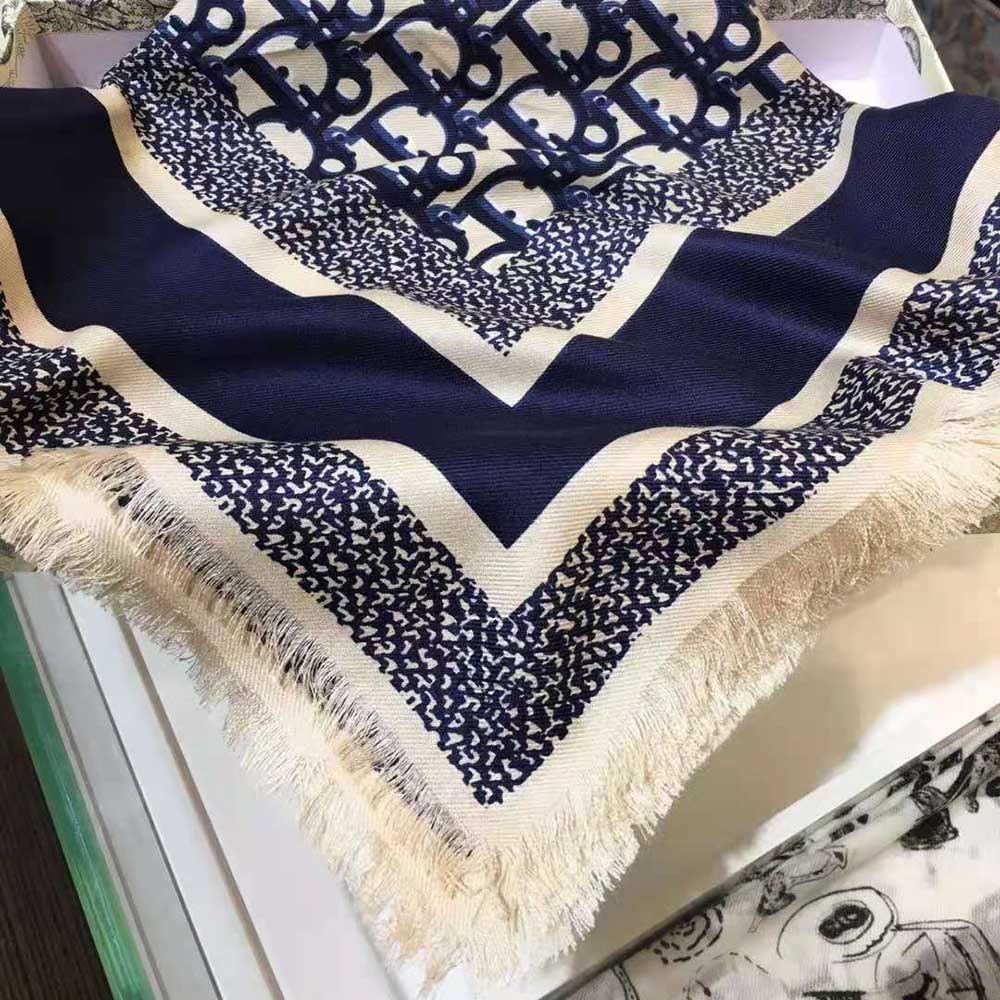 Close-up showing signature Dior Oblique pattern on navy blue silk scarf
