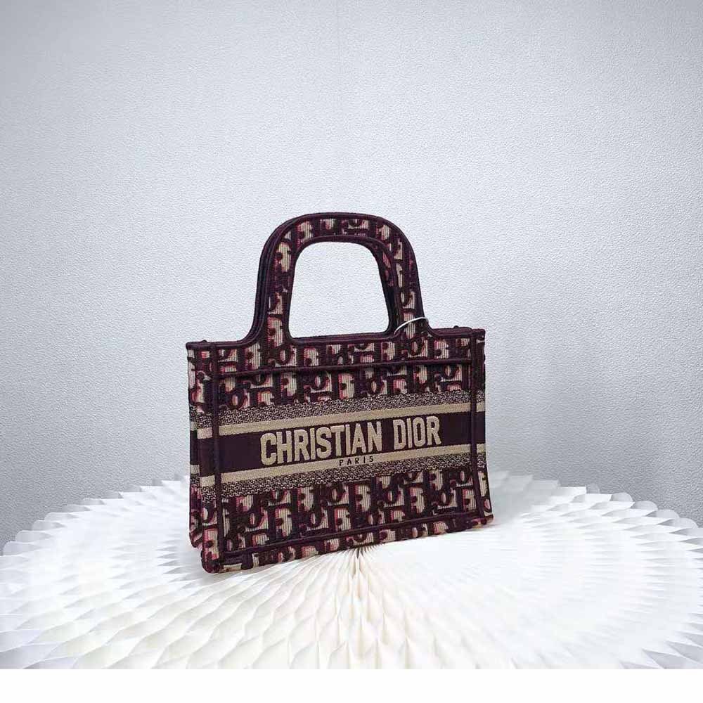 Side angle showing silver-tone hardware on Mini Dior Book Tote Burgundy Dior Oblique Embroidery
