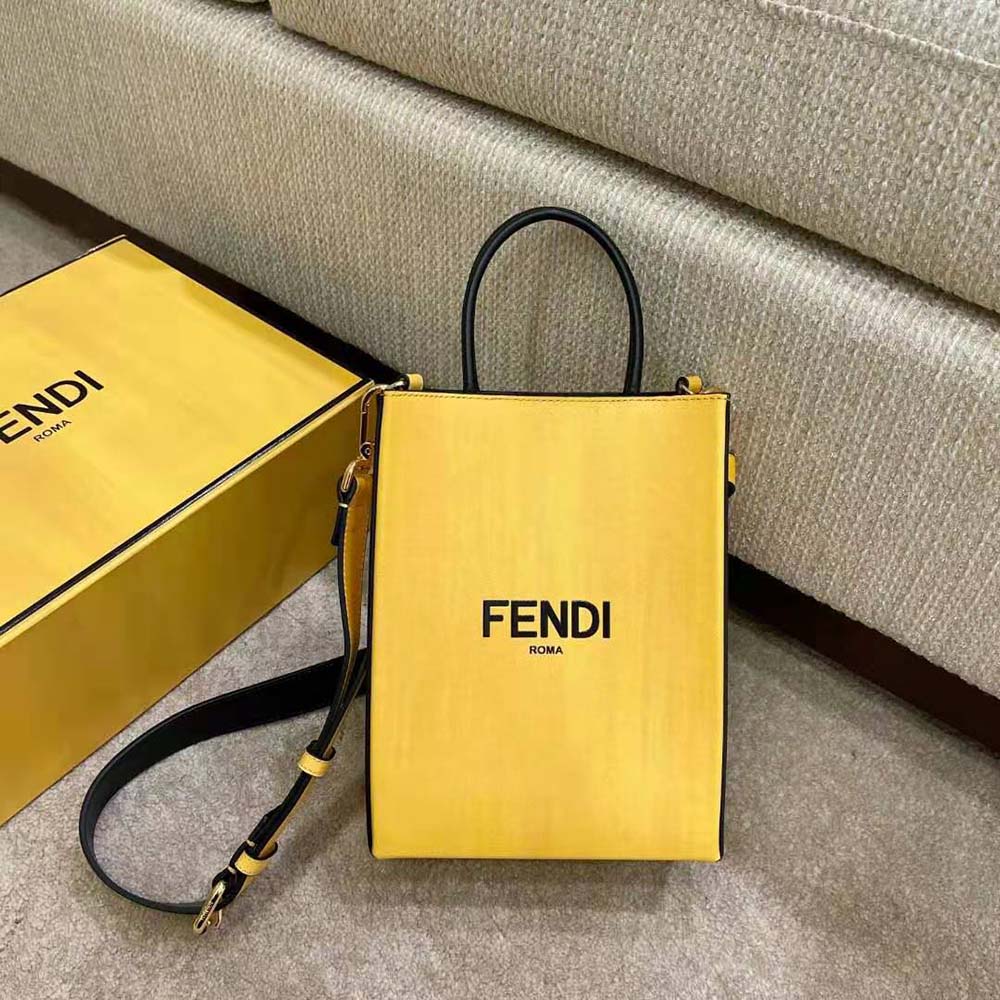 Close-up of yellow leather texture and Fendi logo detail on bag
