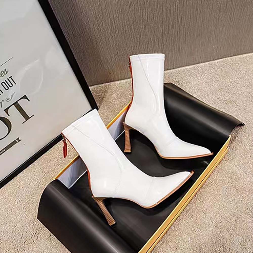 Close-up detail of glossy white leather and metal hardware on Fendi boots