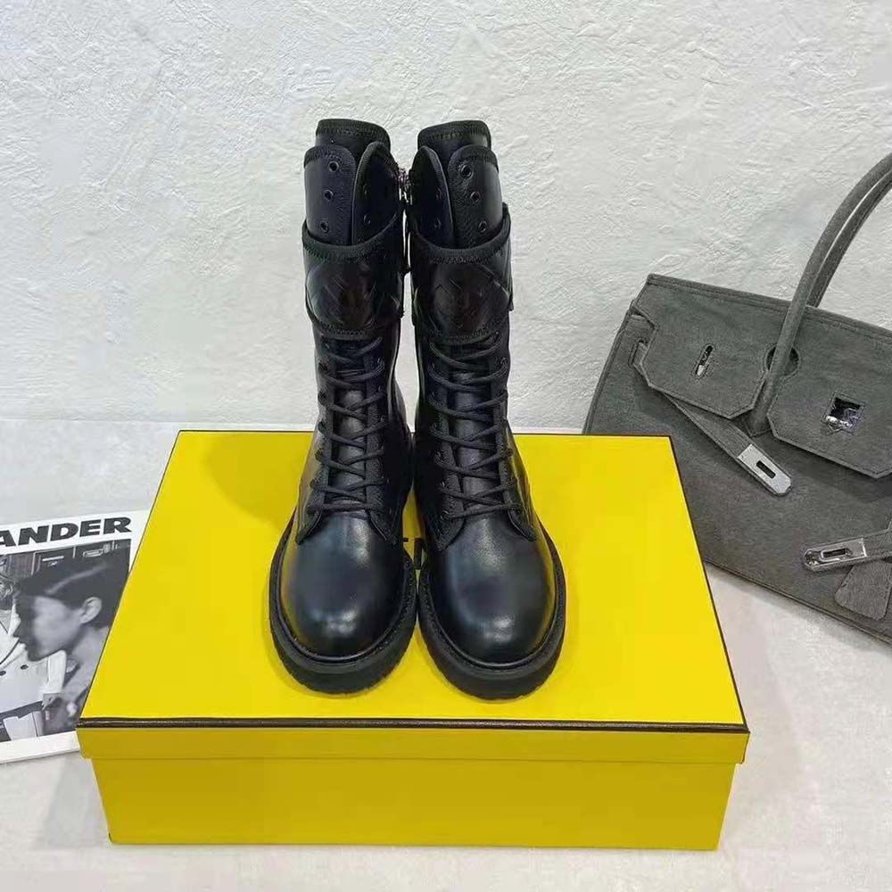 Close-up of embossed Fendi logo hardware on black leather biker boots