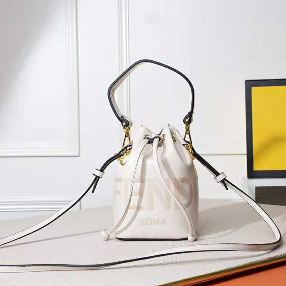 Close-up detail of gold-tone Fendi logo hardware on white mini bag