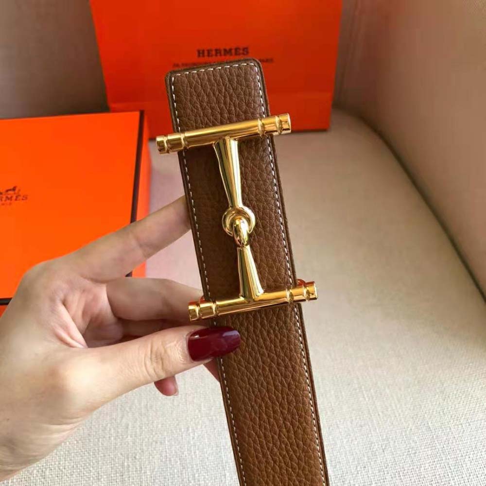 Close-up on the gold-tone H buckle of Hermes reversible leather belt