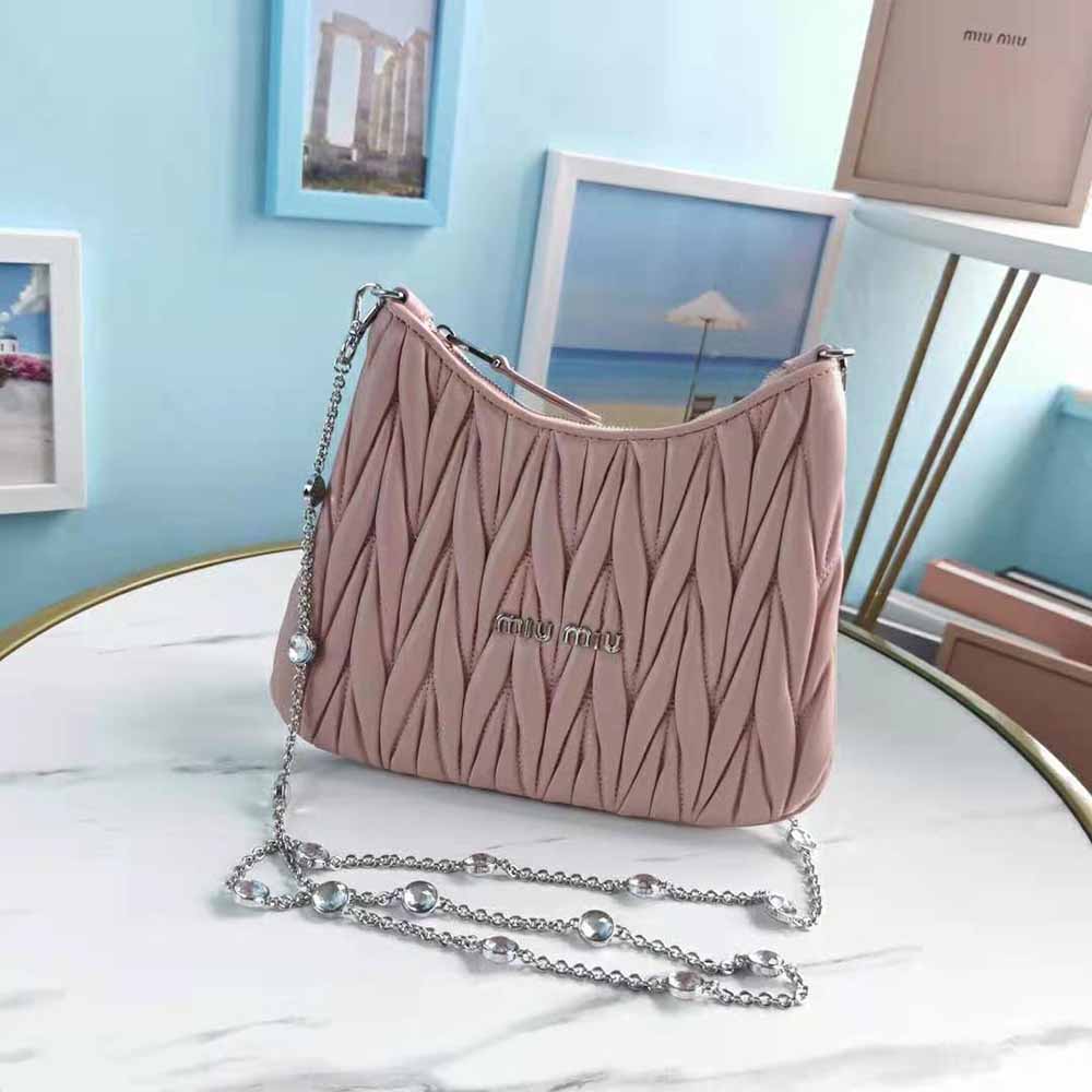 Close-up on gold hardware and matelassé texture of Miu Miu pink shoulder bag