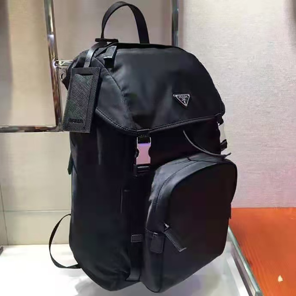 Side angle showing silhouette and zip closure of Prada backpack