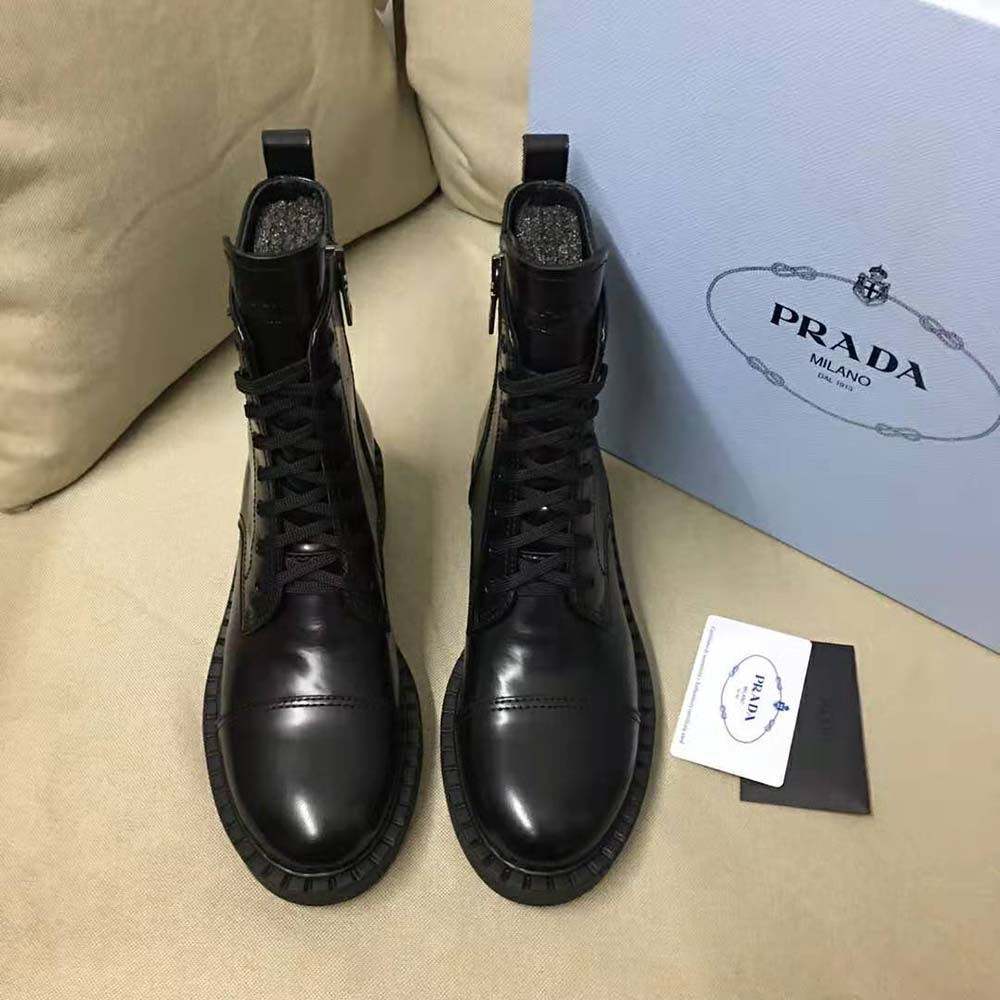 Top view highlighting signature Prada logo hardware on black leather booties