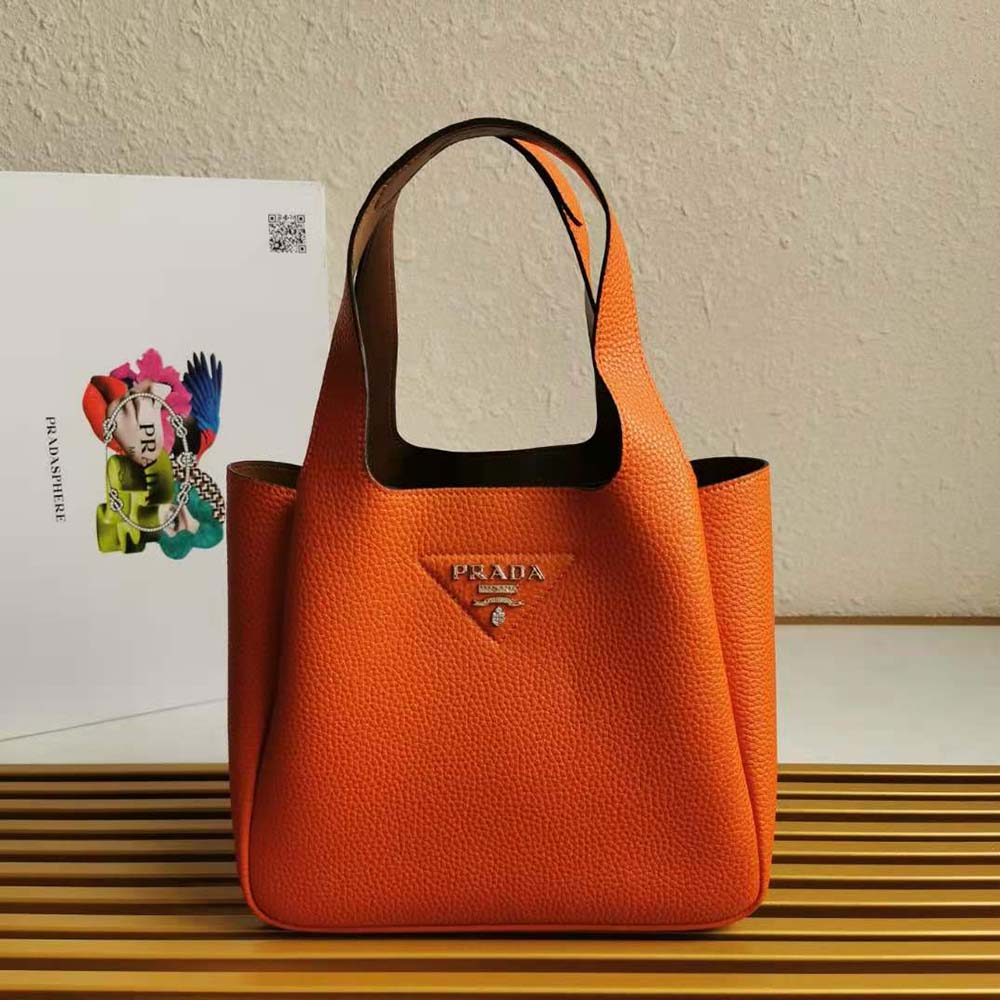Close-up of textured orange calf leather and silver hardware on Prada handbag