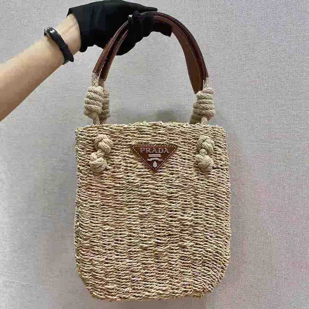 Close-up of woven corn husk and leather trim on Prada tote