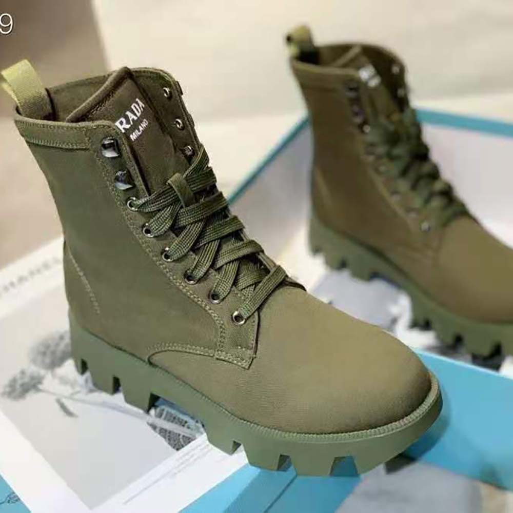 Close-up of laced front and Prada hardware on green denim booties
