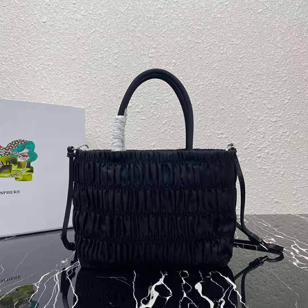 Side angle of Prada Women Embossed Nylon Tote-Black highlighting zipper closure