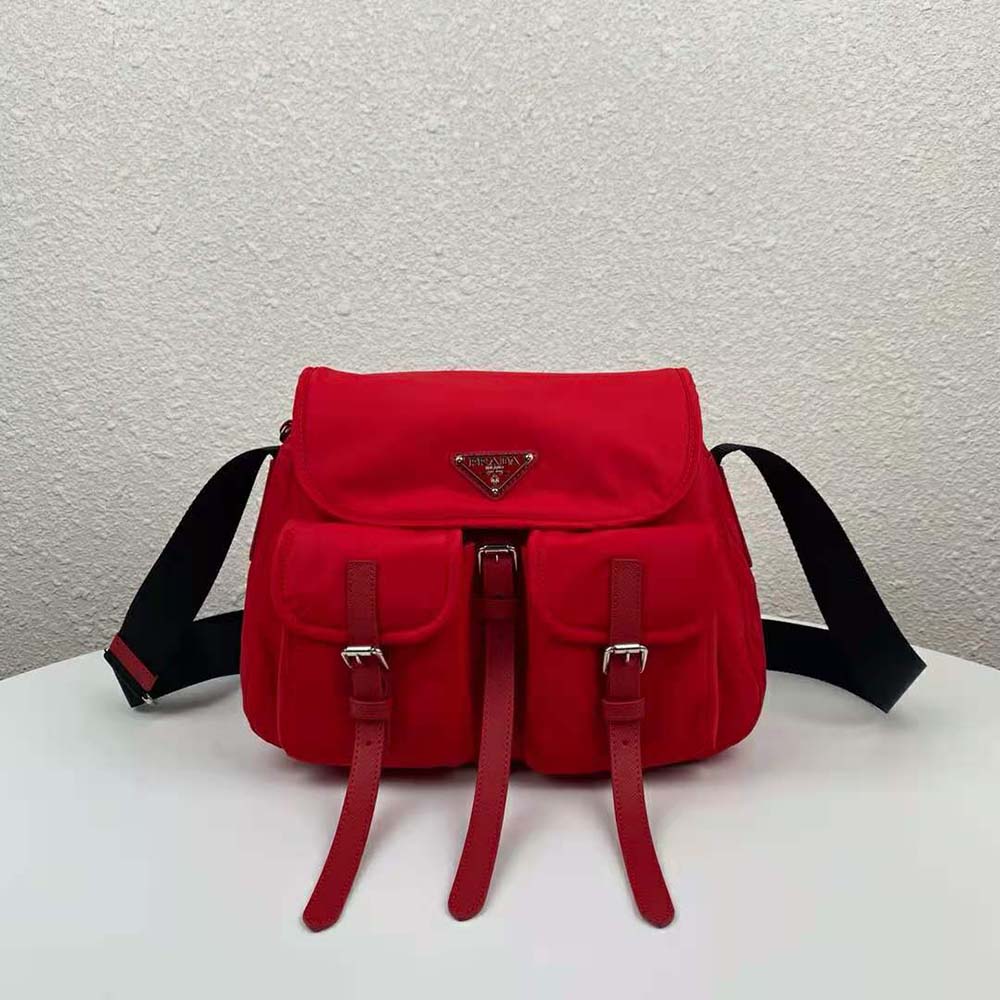 Close-up detail of Prada logo on red nylon shoulder bag