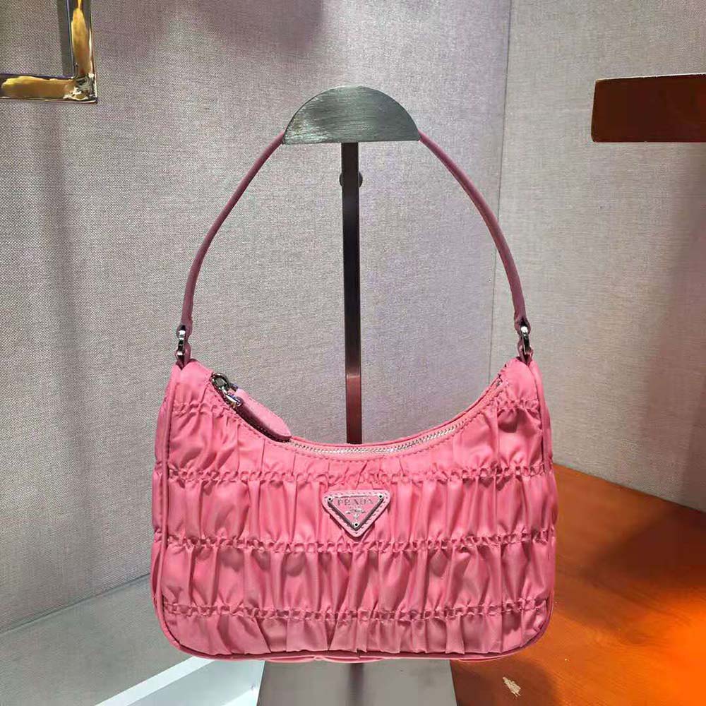 Close-up on Prada logo and silver hardware detail in pink mini bag