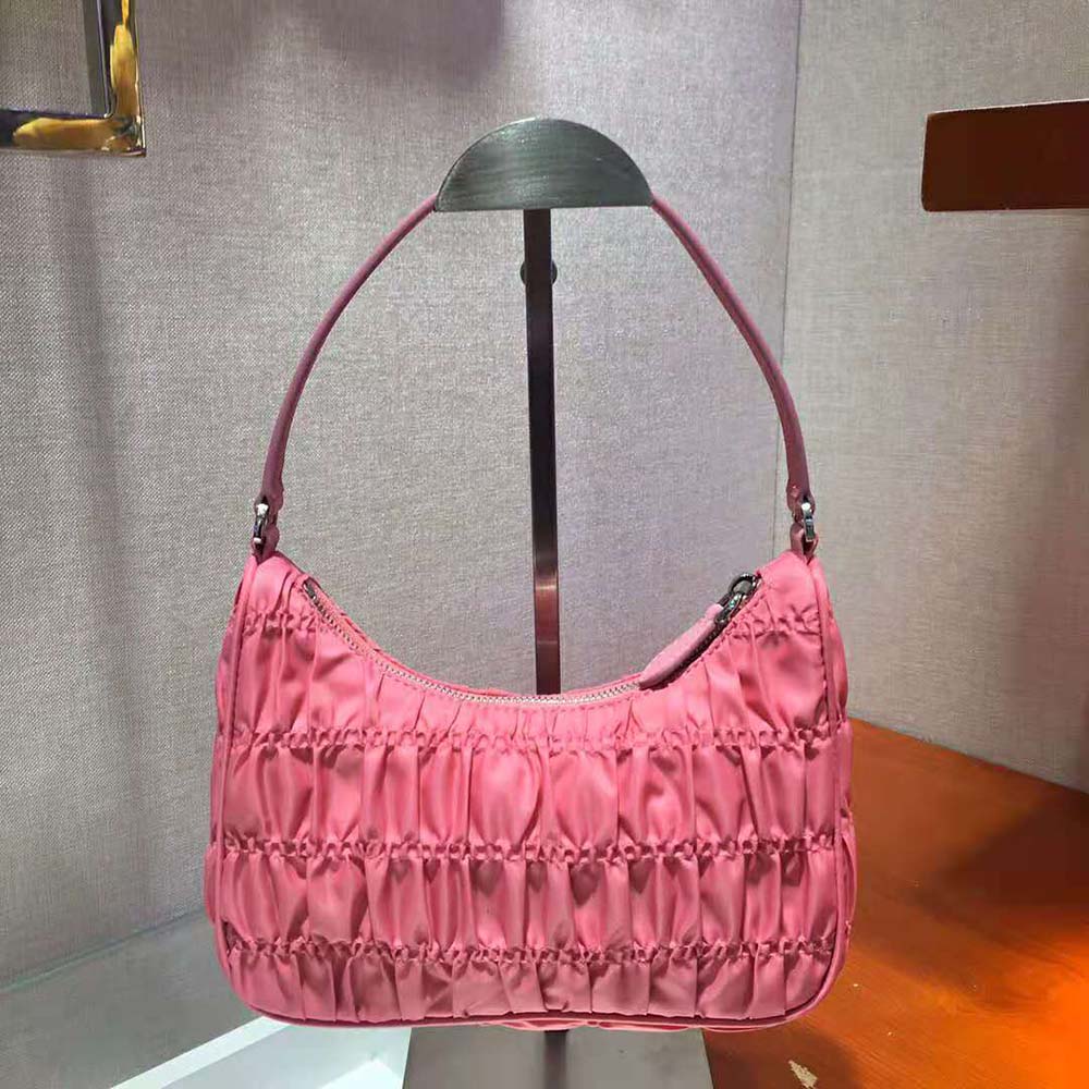 Side angle showing compact shape of Prada Women Nylon and Saffiano Leather Mini Bag-Pink