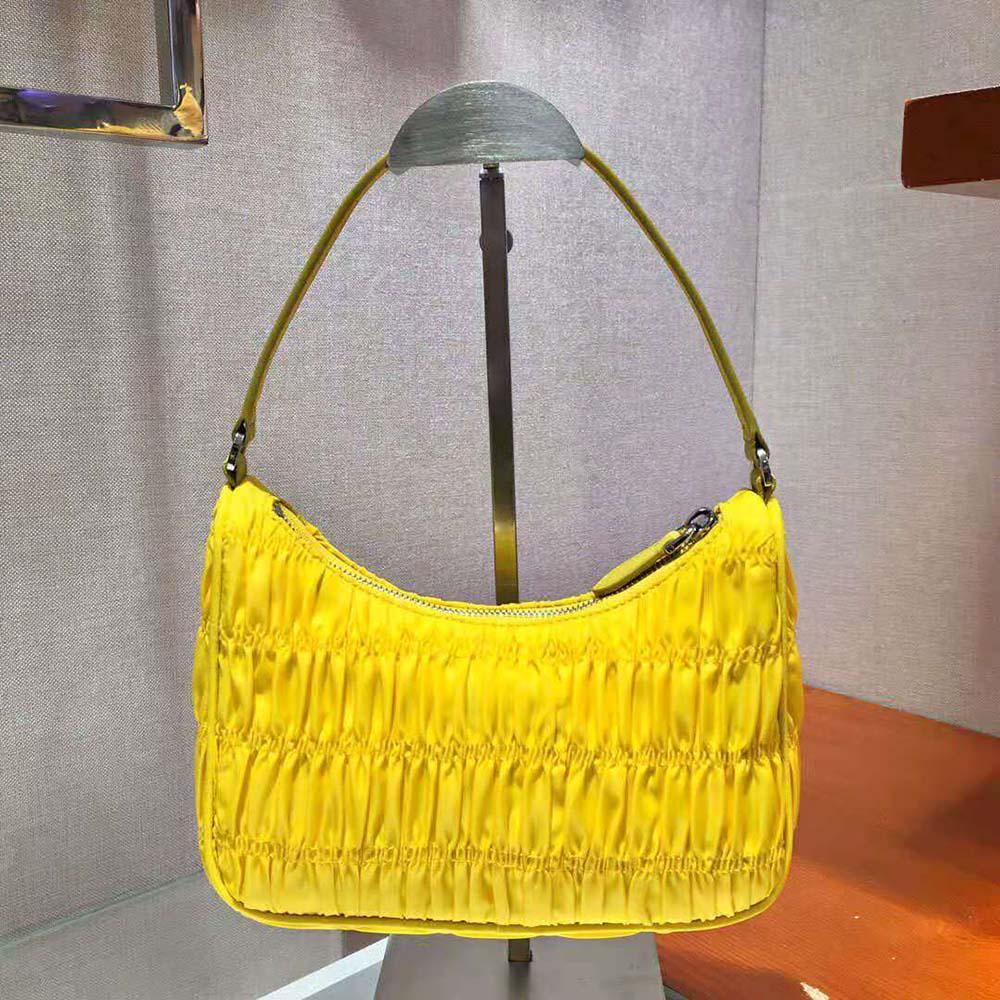 Side angle showing nylon texture and flap closure on Prada mini bag