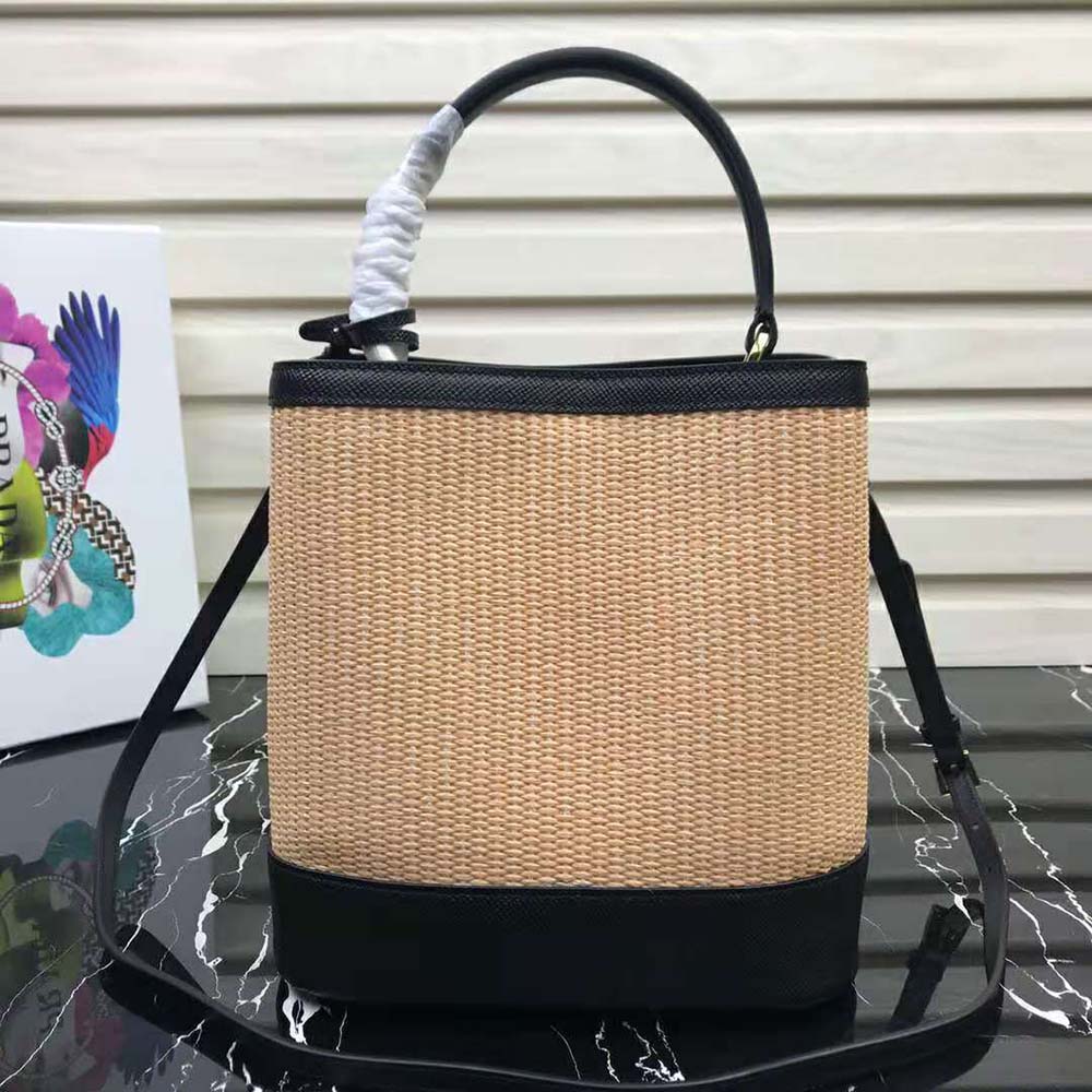 Side angle showing silhouette of Prada Women Prada Panier Medium Straw Bag-Black