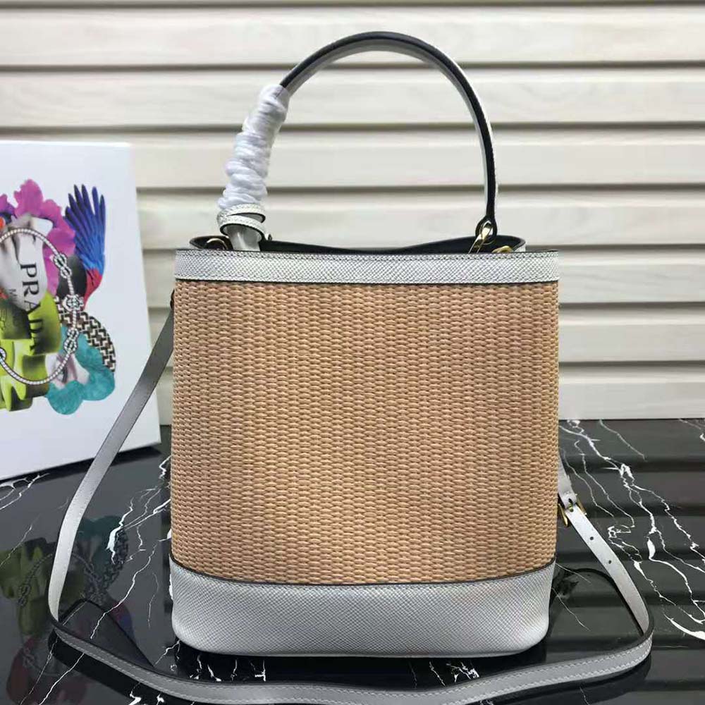 Side angle showing medium silhouette and woven straw texture bag Prada