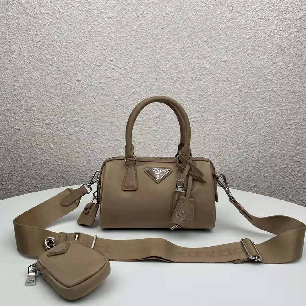 Close-up of Prada logo plaque and silver hardware on nylon bag sandy