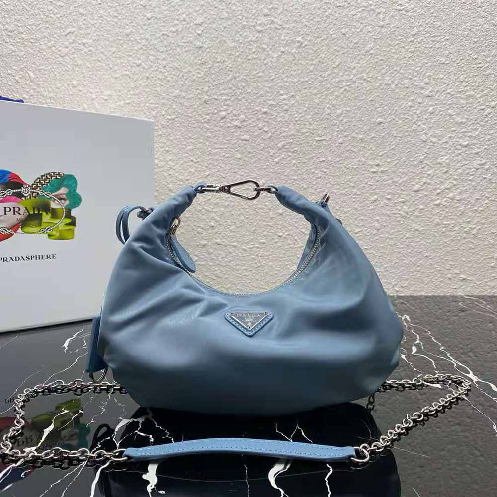 Close-up of silver-tone hardware and Prada logo on blue nylon bag