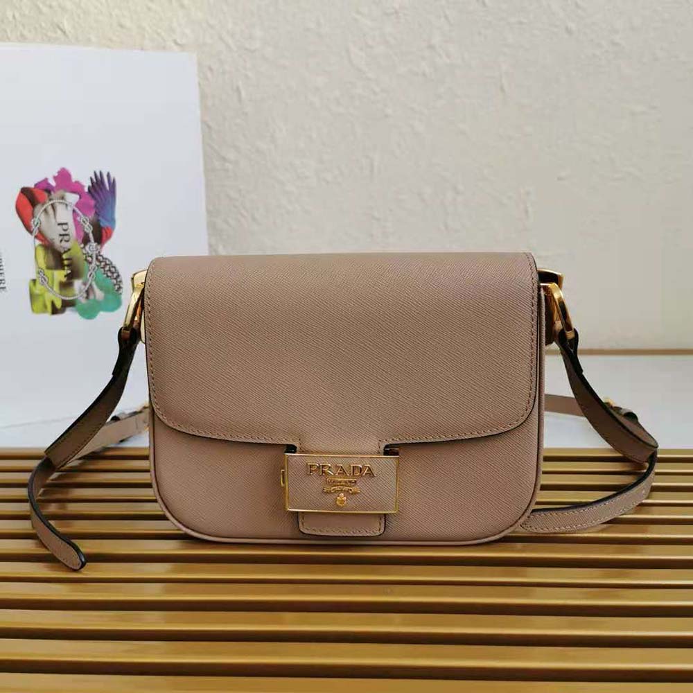 Close-up of gold Prada emblem on pink saffiano leather bag