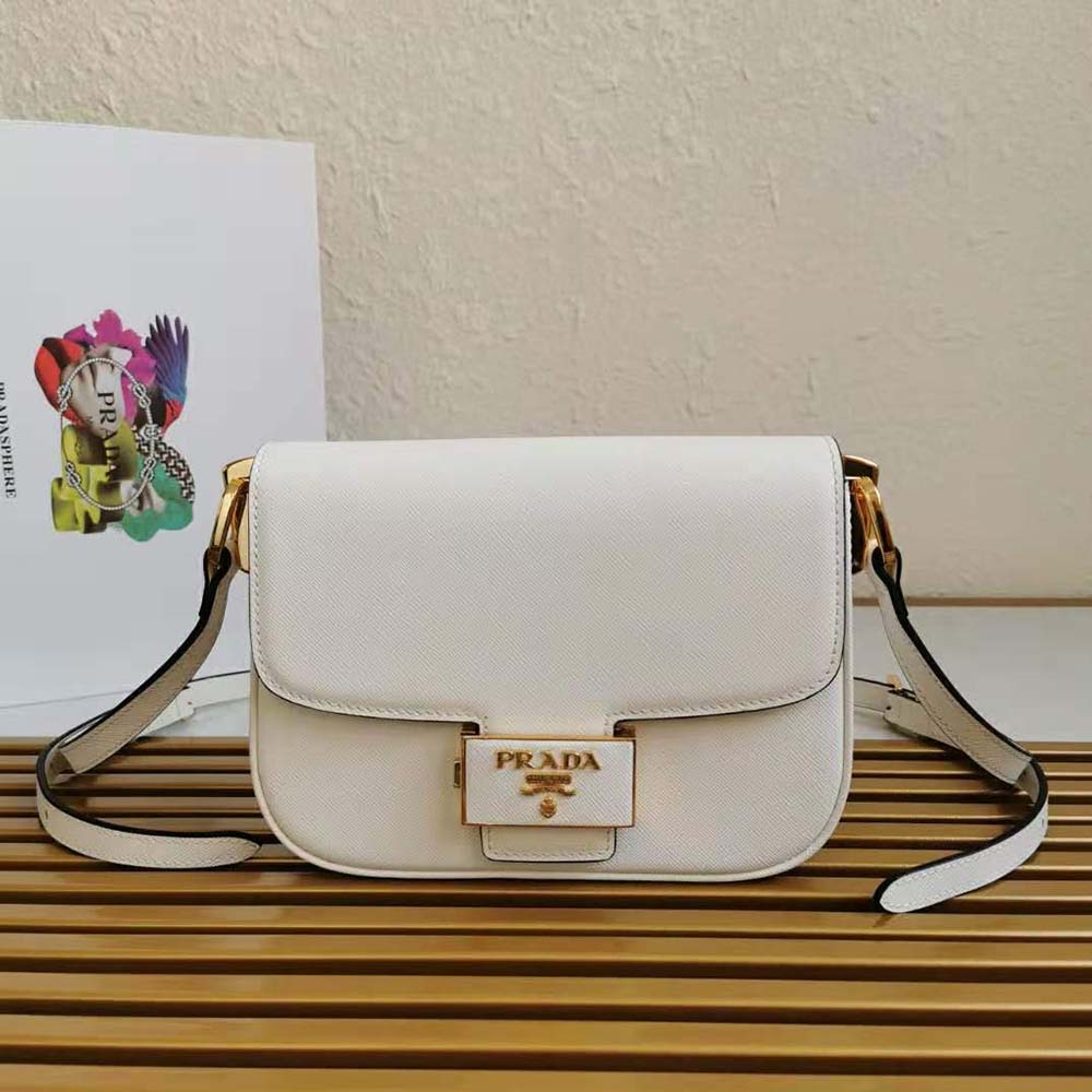 Close-up of silver Prada Embleme hardware on white leather bag