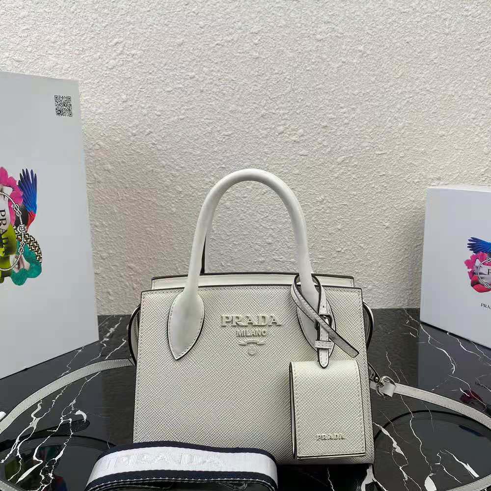 Close-up of silver Prada logo hardware on white leather bag