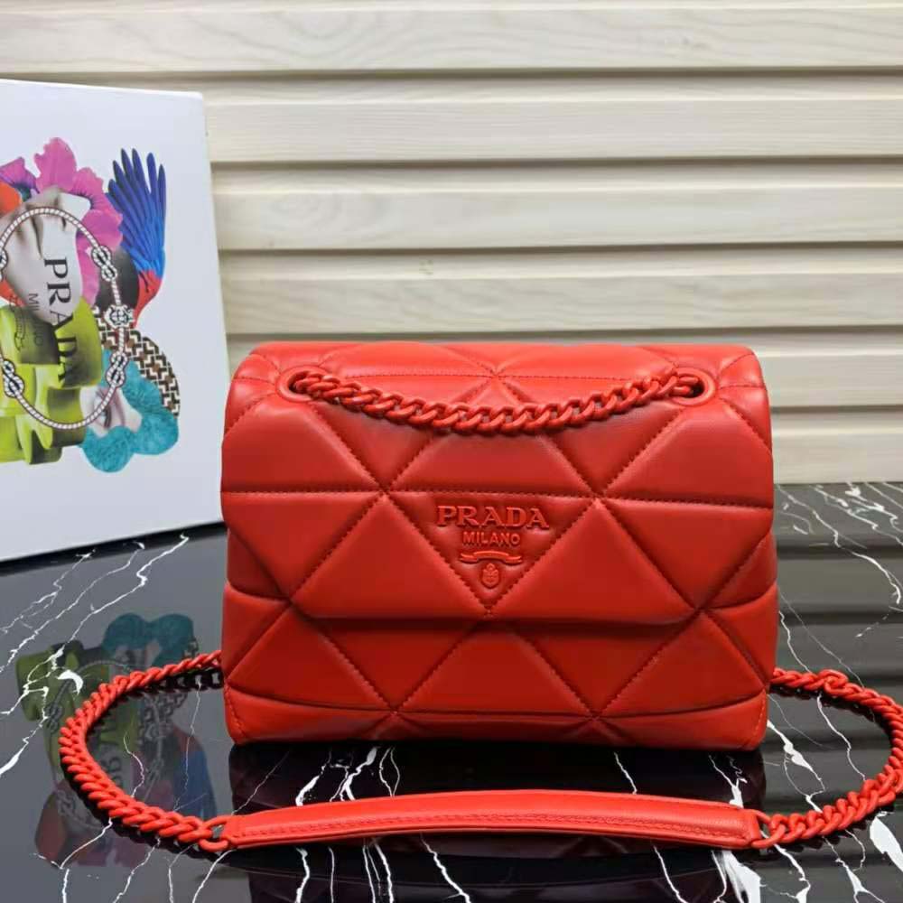 Close-up of gold Prada logo hardware on red Spectrum bag