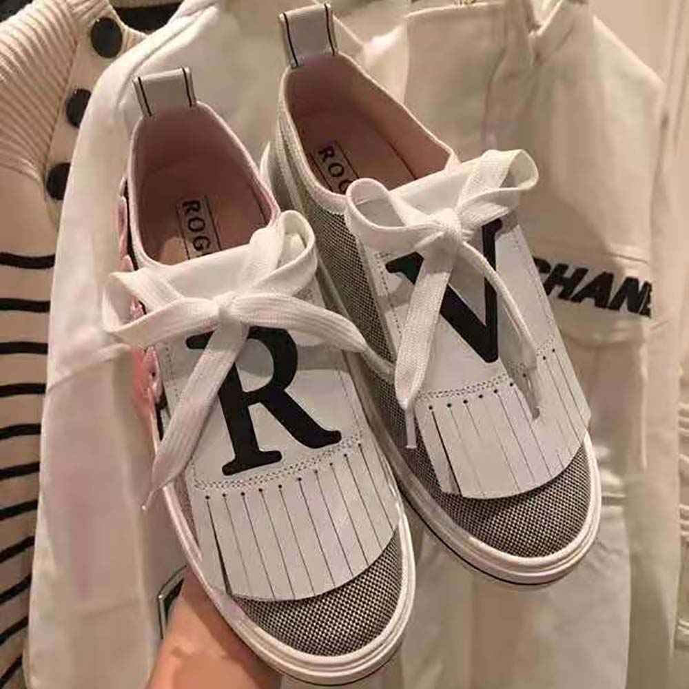 Close-up on signature silver buckle patch of Roger Vivier sneakers