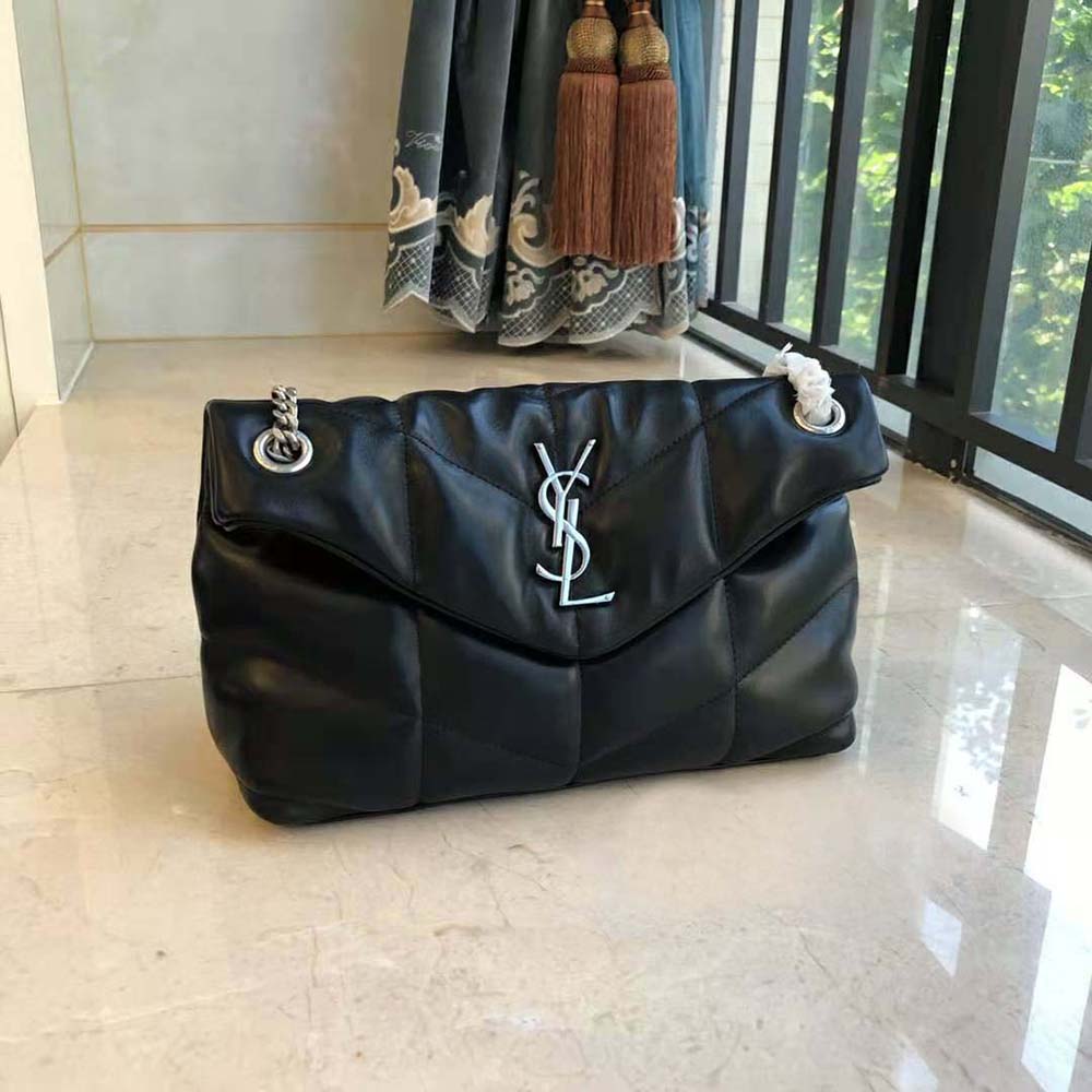 Close-up of gold YSL logo hardware on quilted lambskin bag