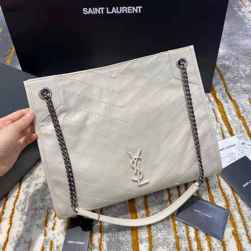 Close-up of gold-tone YSL logo on Saint Laurent Niki Medium Shopping Bag