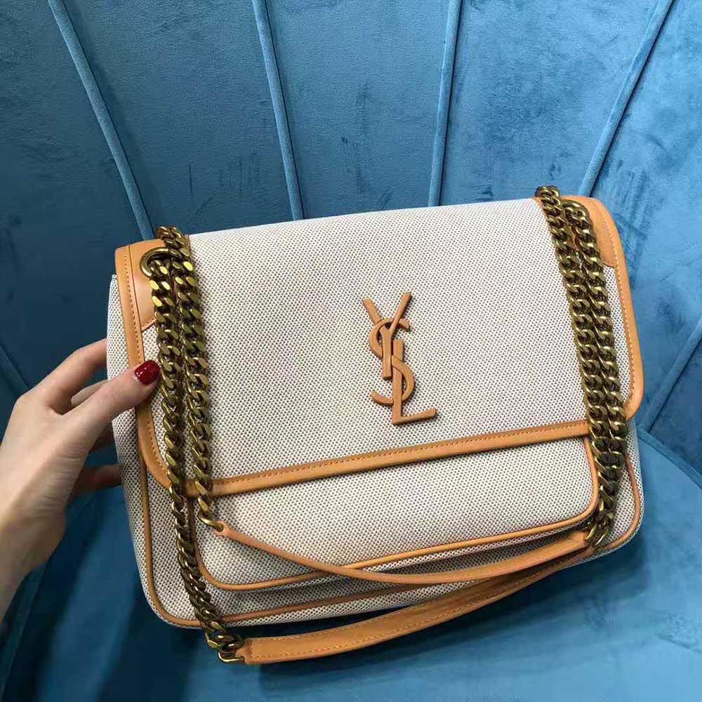 Close-up of antique gold YSL logo on vintage leather flap