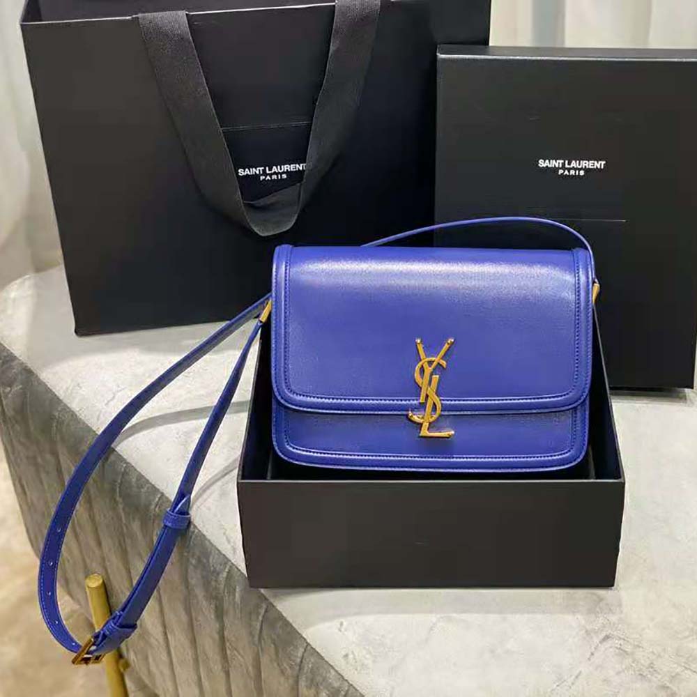 Close-up of gold YSL monogram hardware on blue Solferino medium satchel