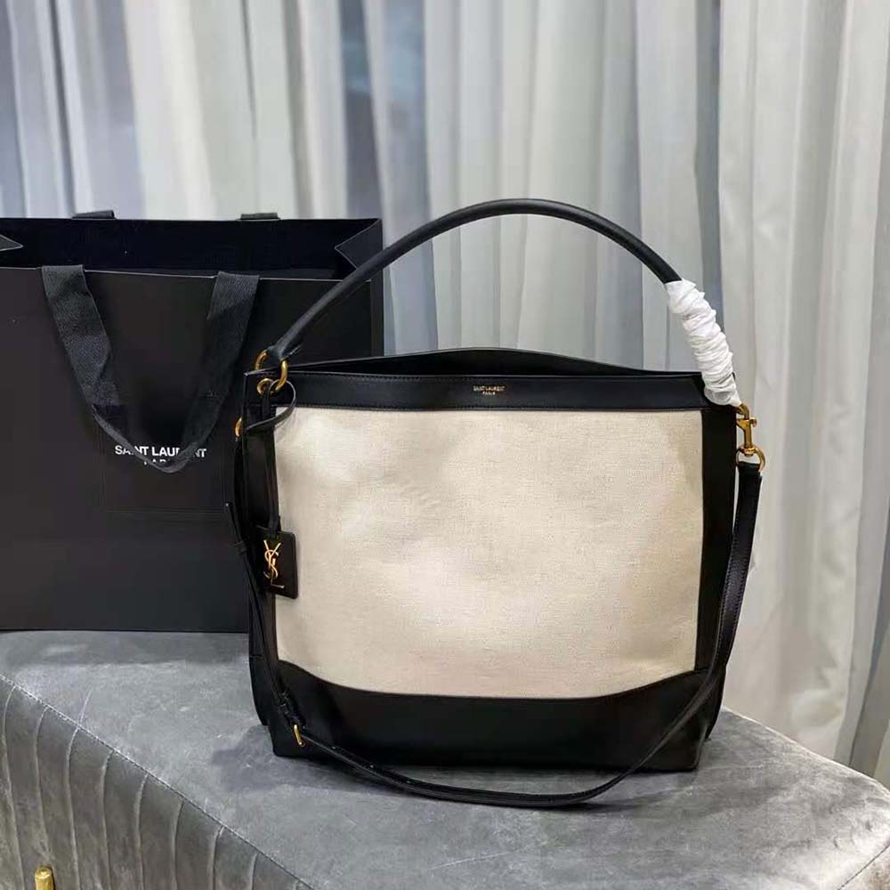 Close-up of gold YSL logo on white leather Saint Laurent hobo bag