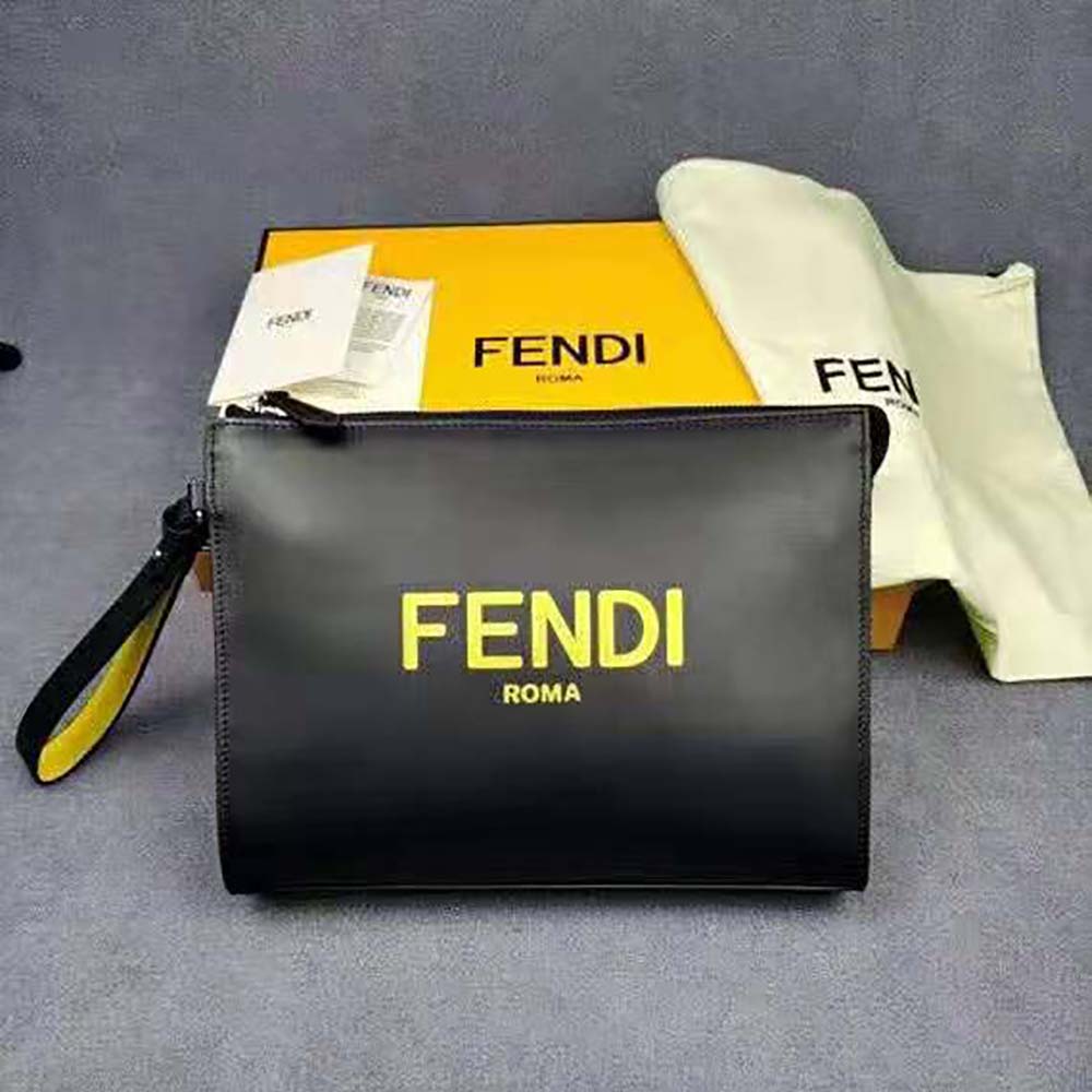 Close-up of brushed gold-tone Fendi logo hardware on black leather pouch